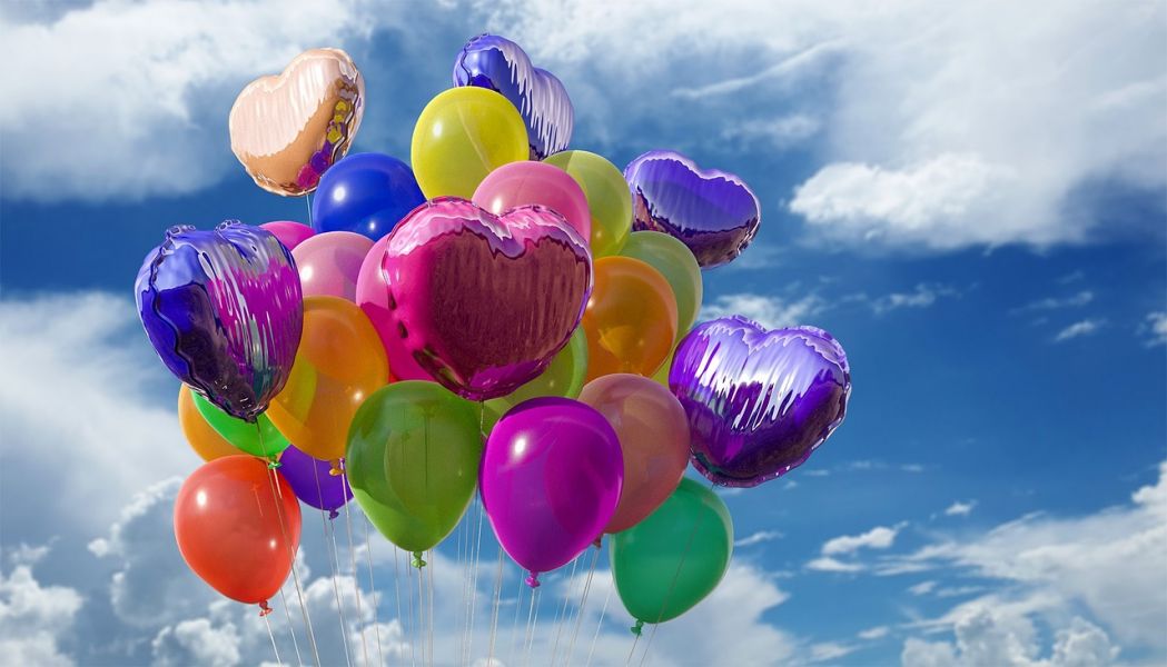 Luftballons und weiter, freier Himmel; ein Gefühl von Freiheit, Raum und Klarheit ensteht.
