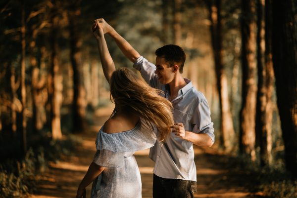 Zwei Personen beim Tanzen im herbstlichen Wald, Gefühl von Zweisamkeit, Freude