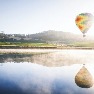 Luftballon über einem See, Felder im Hintergrund, Gefühl von Weite, Klarheit, neuen Erlebnissen